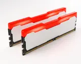 Deux barrettes de RAM pour PC portable, blanches avec un éclairage LED rouge vif. Idéal pour ajouter de la performance.