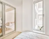 Puerta corredera de cristal que da a un salón. Explora los tipos de cristales para puertas de interior y cómo iluminan tu hogar.