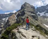 Kobieta z kijkami trekkingowymi na szlaku w Dolinie Gąsienicowej, pod majestatycznym szczytem.