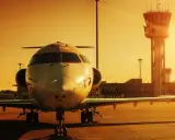 Ett privatjet står parkerat på en flygplats på Cypern vid solnedgången, med kontrolltornet i bakgrunden.