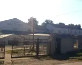 Brama wjazdowa do Browaru Tenczynek. W tle budynki browaru i wysoki komin.
