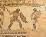 Antikes Mosaik zeigt zwei Gladiatoren im Kampf. Ein Gladiator mit Schild und Schwert, der andere mit einem Speer. Sie kämpfen, was ist ein Gladiator?