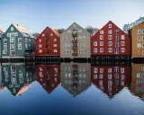 Kolorowe domy nad wodą, odbijające się w spokojnej tafli. Idealne miejsce na pracę z norweskim, podziwiając architekturę.