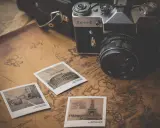 Stara kamera Zenit-E, mapy i pocztówki z podróży. Idealny zestaw do fotografii poradnikowej, by uchwycić wspomnienia.