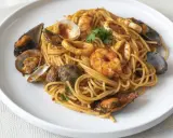 Espaguetis a la marinera con gambas, mejillones, calamares y almejas, todo bañado en una rica salsa de tomate.