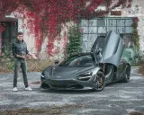 Mężczyzna prezentuje szarego McLarena 720S z otwartymi drzwiami. Zastanawiasz się nad mclaren 720s cena?