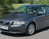 Szary Volvo S40 2.0 diesel w ruchu, z rozmytym tłem zieleni i drogi.