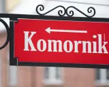 Tabliczka "Komornik" z białą strzałką w lewo. Zastanawiasz się, ile komornik może zabrać z emerytury?