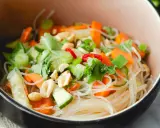 Frischer Glasnudel Salat mit Karotten, Gurken, Frühlingszwiebeln und Erdnüssen in einer Schüssel.