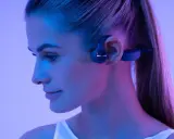 Une femme porte un casque à conduction osseuse. Ce type de casque peut présenter un danger si l'on n'est pas attentif à son environnement.