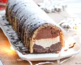 Bûche glacée chocolat, vanille et chocolat, saupoudrée de sucre glace. Une délicieuse recette pour les fêtes.