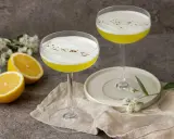 Två eleganta glas med en gul Galliano drink, toppad med vitt skum och strödd kanel. Citroner och blommor ger en fräsch touch.