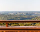 Widok z kaszubskiej wieży widokowej na zalesione wzgórza i jezioro.
