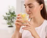 Kobieta pije wodę z cytryną. To świetny sposób, by dowiedzieć się, co pić na poprawę wzroku.