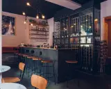 Mysig vinbar i Stockholm med en stor vinkyl, bardisk och sittplatser.