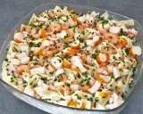 Salade Marco Polo : pâtes, crevettes, bâtonnets de surimi et ciboulette dans un plat en verre.