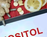 Tablet z napisem "INOZYTOL CO TO". Obok imbir, plasterki cytryny, kapsułki i tabletki.