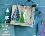 Selbstgebastelte Weihnachtskarten mit Bäumen, Sternen und Schriftzug "Merry X-Mas".