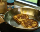 Dos tostadas francesas dorándose en una sartén de acero inoxidable, mostrando las ventajas e inconvenientes de este material para cocinar.