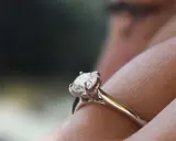 Un anello di fidanzamento con diamante solitario, un classico tra i tipi di anelli di fidanzamento, brilla su un dito.