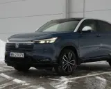 Ciemnoniebieski Honda HR-V na tle śniegu i szarej ściany.