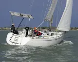 Voilier Dufour 34 en navigation, voiles blanches gonflées par le vent. La fiche technique de ce bateau est impressionnante.