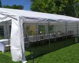 Gotowy namiot bankietowy z długim stołem i krzesłami. Idealny na przyjęcie, pokazuje jak rozłożyć namiot.