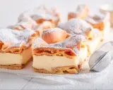 Kremówka papieska, jeden z 10 najlepszych ciast, posypana cukrem pudrem.