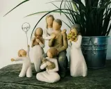 Eine griechische Familie aus Figuren: Vater, Mutter, zwei Mädchen, ein Junge und ein Baby. Ein Mädchen hält ein Buch, ein anderes Sonnenblumen.