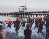 Triathleten starten ins Wasser, die Menge jubelt vom Steg. Die Ironman Vorbereitung ist in vollem Gange.