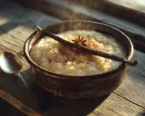 Un bol fumant de riz au lait, garni d'une gousse de vanille et d'anis étoilé. Parfait pour des recettes de riz au lait réconfortantes.