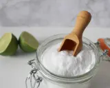 Bicarbonato e lime, ingredienti naturali per combattere la forfora. Un cucchiaino di bicarbonato in un barattolo di vetro.