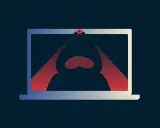 Ein Laptop mit einer roten Linse, die einen Hacker im Kapuzenpullover im Inneren beleuchtet. Das Bild symbolisiert das **webcam hacken**.