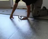Instalando la mejor base aislante para suelo laminado. Se coloca una lámina plateada reflectante, asegurando un aislamiento térmico y acústico óptimo.