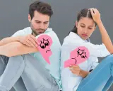Coppia seduta schiena contro schiena, ognuno con un cuore spezzato. Simboleggia le difficoltà del diritto di famiglia, forse con la riforma Cartabia.
