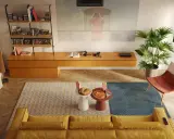Un divano giallo accogliente, tavolini con pizza e popcorn, e una proiezione sul muro: perfette idee salotti piccoli per serate cinema.