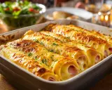 Crêpes au jambon et fromage, gratinées au four avec une sauce béchamel onctueuse. Un délice fumant !