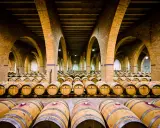 Bodegas subterráneas con hileras de barricas de vino, evocando la tradición del Camino de Santiago. Una fuente de vino para peregrinos.