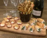 En flaska Bollinger och en bricka med läckra tilltugg till bubbel: små salta korgar, smördegsrullar och ostpinnar.