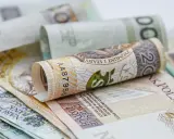 Zrolowane polskie banknoty o nominałach 20, 100 i 200 złotych.