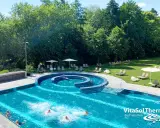 Außenpool der VitaSol Therme Bad Salzuflen mit Liegen und Bäumen.