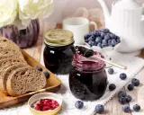 Un petit-déjeuner gourmand avec du pain de campagne, des myrtilles fraîches et une délicieuse confiture de myrtilles.