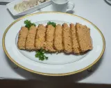 Pokrojona pasztetowa na talerzu, ozdobiona natką. Czy można mrozić pasztetową? Tak, po rozmrożeniu zachowuje smak.