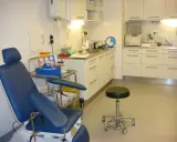 Blå undersökningsstol och medicinsk utrustning i ett kliniskt rum. Förberedelser för att testa för tyfoidfeber.