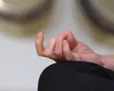 En hand i meditationsställning, fingrarna böjda i en gest som påminner om sa ta na ma. Lugn och ro.
