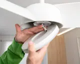 Manos conectando cables para como instalar un ventilador de techo con luz.