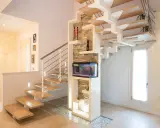 Moderna scala interna in legno e metallo con acquario integrato. Il design innovativo suggerisce un interessante costo scala interna.