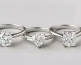 Tre anelli con diamanti: uno a taglio rotondo, uno a cuore con un piccolo baguette ai lati, e uno a taglio cuscino. Il baguette significato è eleganza.