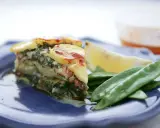 Laxpudding med gravad lax, potatis och dill. Serveras med sockerärtor och citronklyfta.