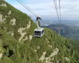 Kolejka linowa wjeżdża na zbocze porośnięte kosodrzewiną, oferując widok z Kasprowego na Giewont.